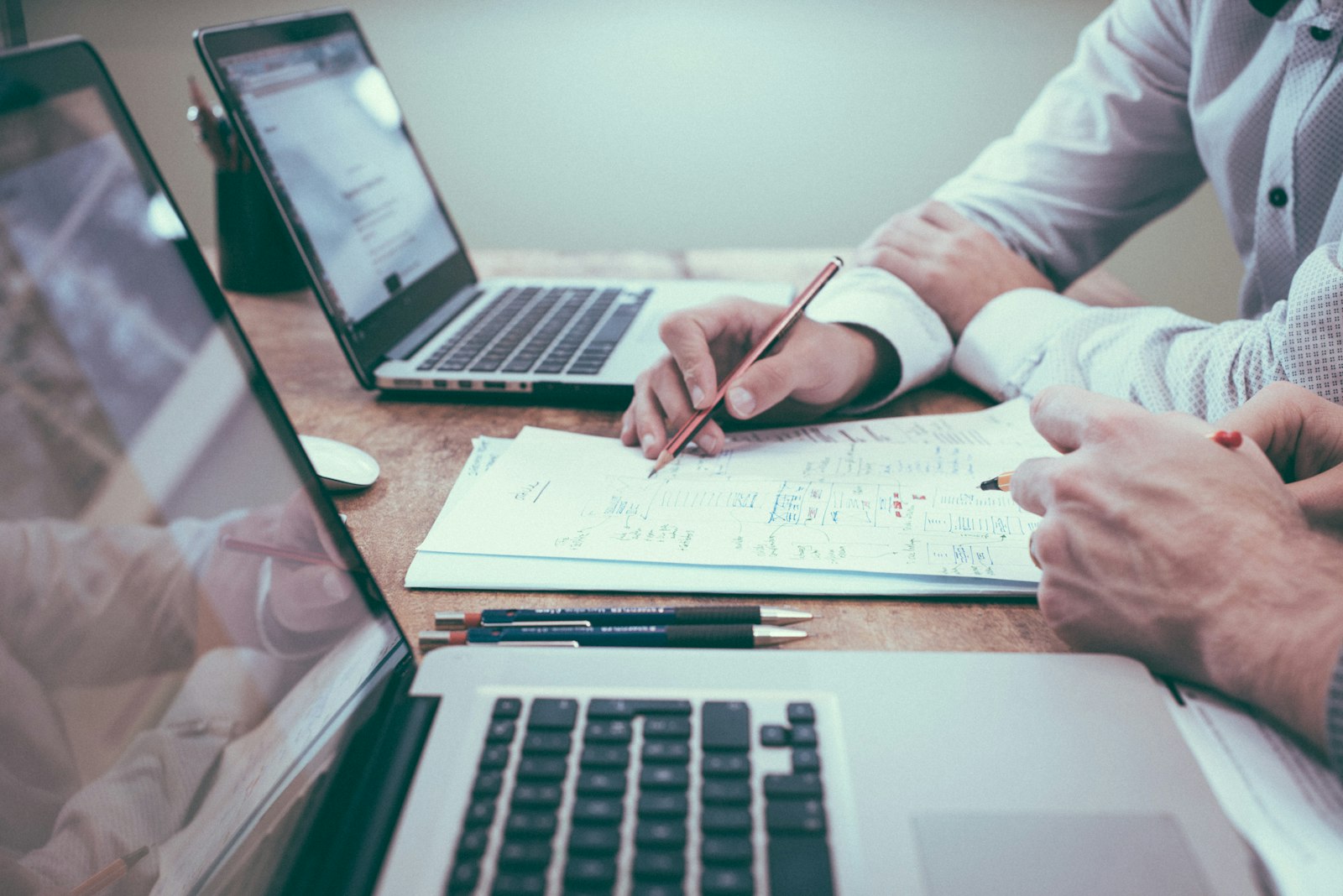 Two people reviewing paperwork and a laptop together at a desk