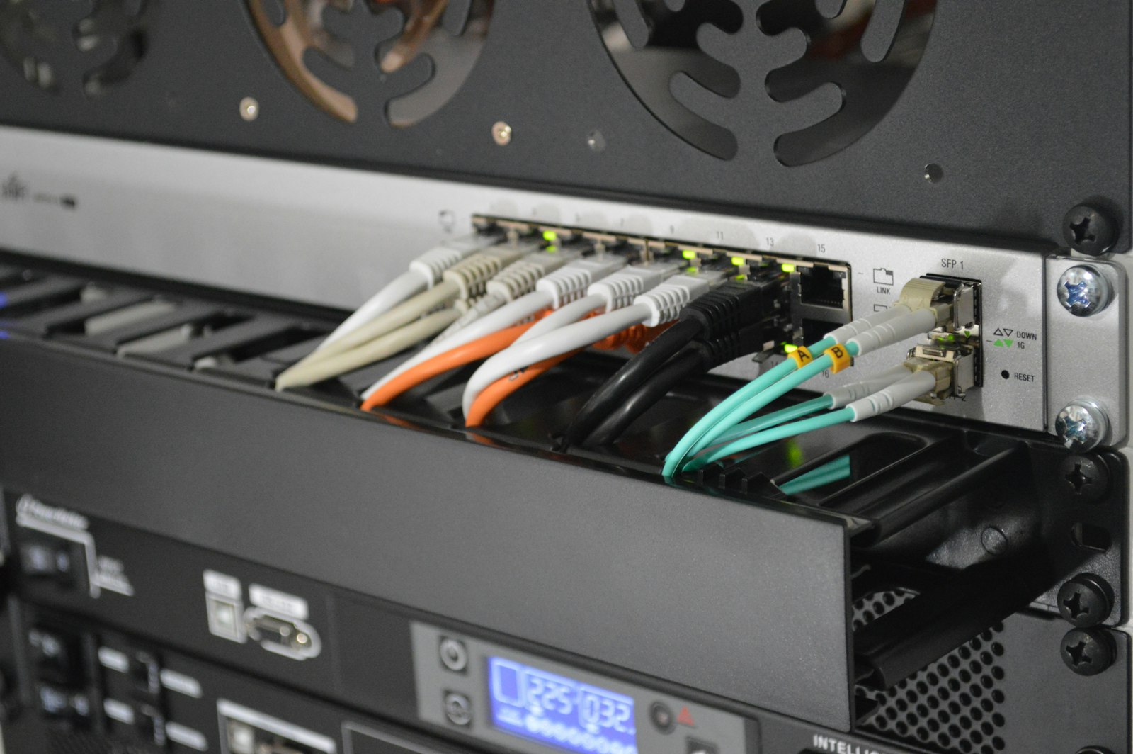 A network switch in a rack with fiber and ethernet cables connected